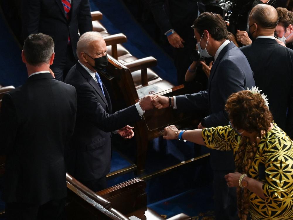 President Biden fist-bumps members of Congress as he arrives in the U.S. Capitol to deliver his joint address.