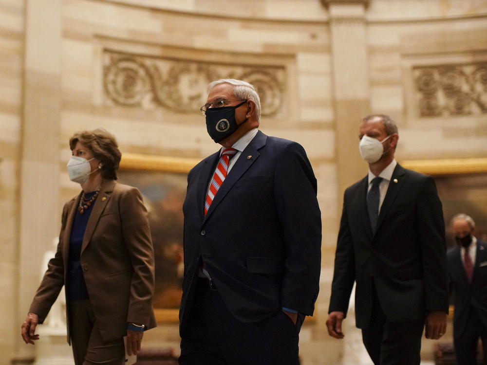 Sen. Robert Menendez, a Democrat from New Jersey (center), wears a protective mask while passing though the Rotunda of the U.S. Capitol.