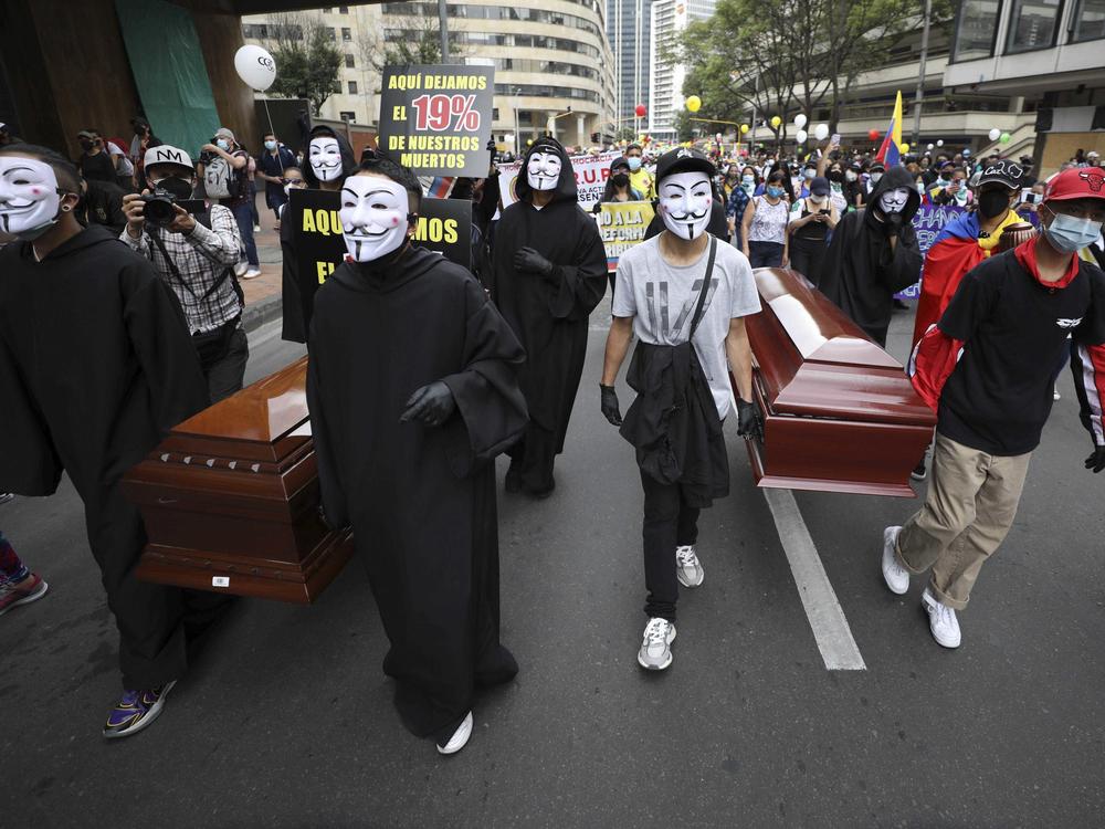 Protesters wearing Guy Fawkes masks carry empty coffins during a national strike to protest a government proposal that would raise taxes, in Bogotá, Colombia, on Wednesday.