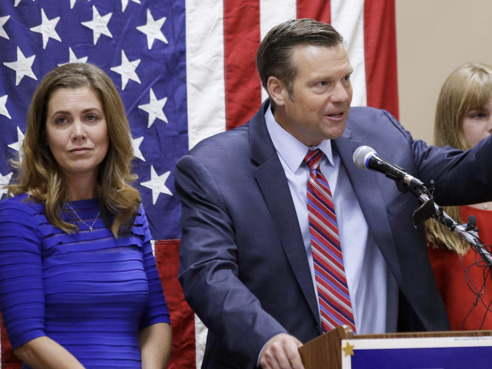 Kris Kobach, right, seen here conceding the Republican primary for U.S. Senate on Aug. 4, 2020 in Leavenworth, Kan. His wife, Heather Kobach, is to his left. Thursday he announced his run for the office of Kansas attorney general.