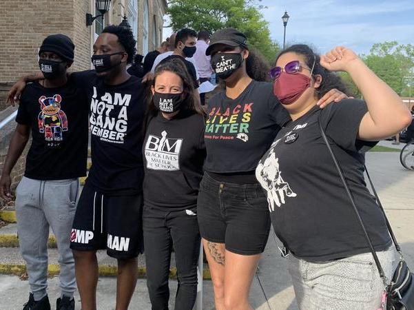 Amy Donofrio (center) and former students stand outside Robert E. Lee High. Donofrio is wearing a shirt that reads 