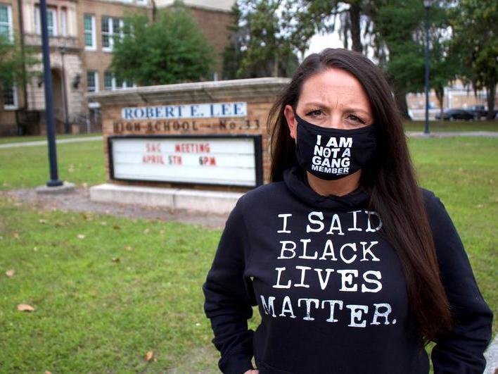 Amy Donofrio stands in front of Robert E. Lee High School in Jacksonville, Fla. She was suspended from teaching duties after she refused to take down a Black Lives Matter flag from outside her classroom.