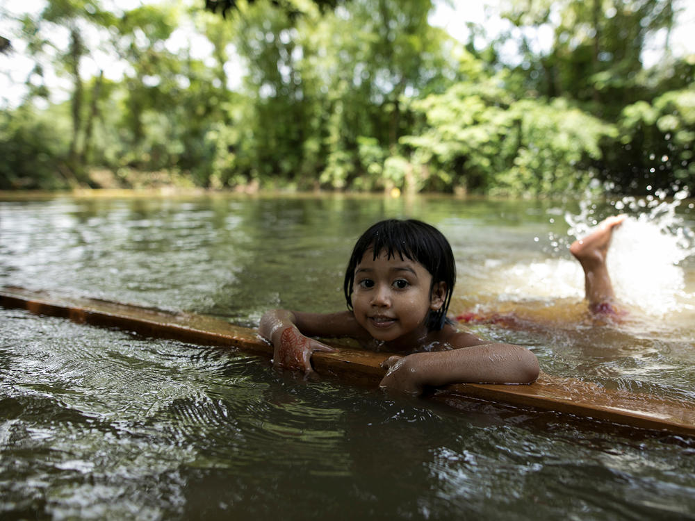 A child learns to swim in a pond in a rural area of Bangladesh.