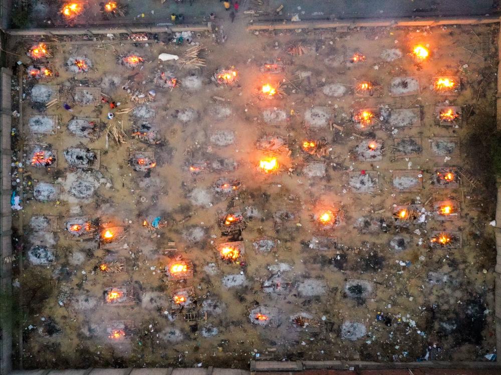 Victims of COVID-19 are cremated in funeral pyres this week in New Delhi. Scientists says the real death toll and number of infections are likely much higher than what the Indian government is reporting.