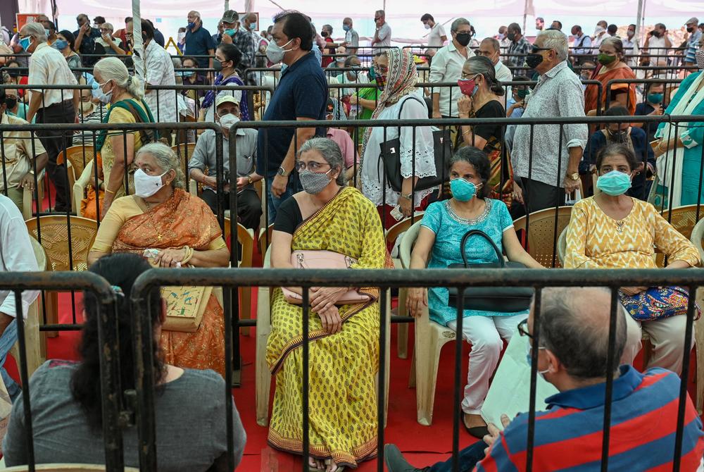 People line up to receive a COVID-19 vaccine on Tuesday in Mumbai.