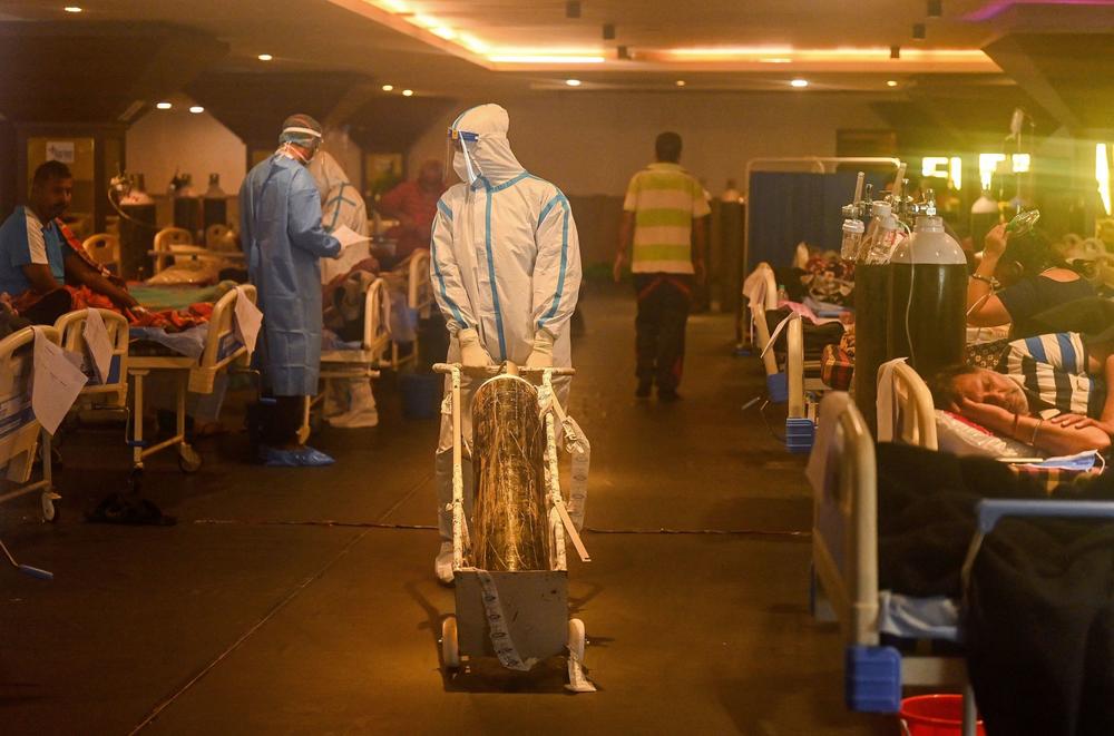 Health workers in protective gear tend to patients Wednesday in a banquet hall temporarily converted into a COVID-19 care center in New Delhi.