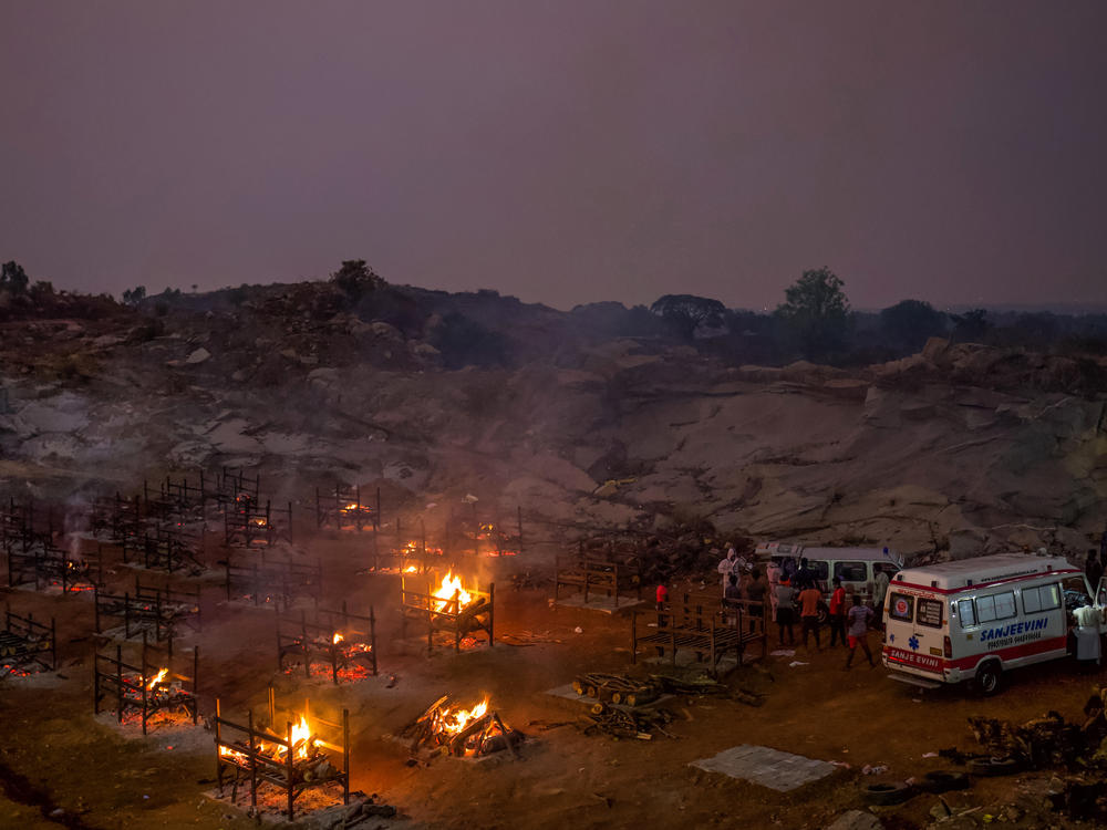 Funeral pyres burn in a disused granite quarry repurposed to cremate the dead due to COVID-19 on Friday in Bengaluru, India. The U.S. is set to impose new travel restrictions against travelers from the country.