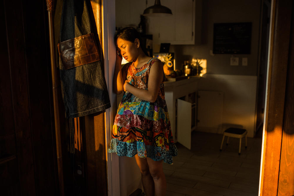 Cham Junglas, 29, rests her head against the door as she works through her labor pains for the home birth of her second child, Theodore. Junglas felt that the hospital experience of her first labor removed her from the intimate experience of birthing her child.