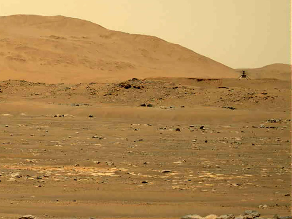 In this image taken by the Mars Perseverance rover and made available by NASA, the Mars Ingenuity helicopter, right, flies over the surface of the planet on Friday.