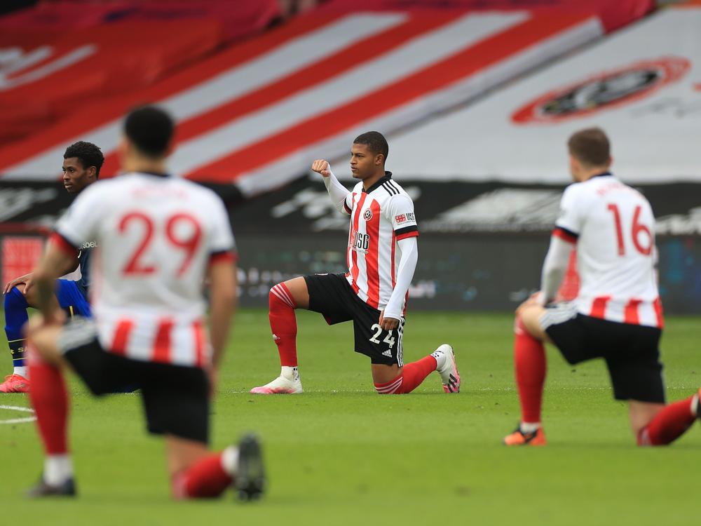 Sheffield United's English striker Rhian Brewster joins other players in taking a knee against racism ahead of kick off of the English Premier League football match.