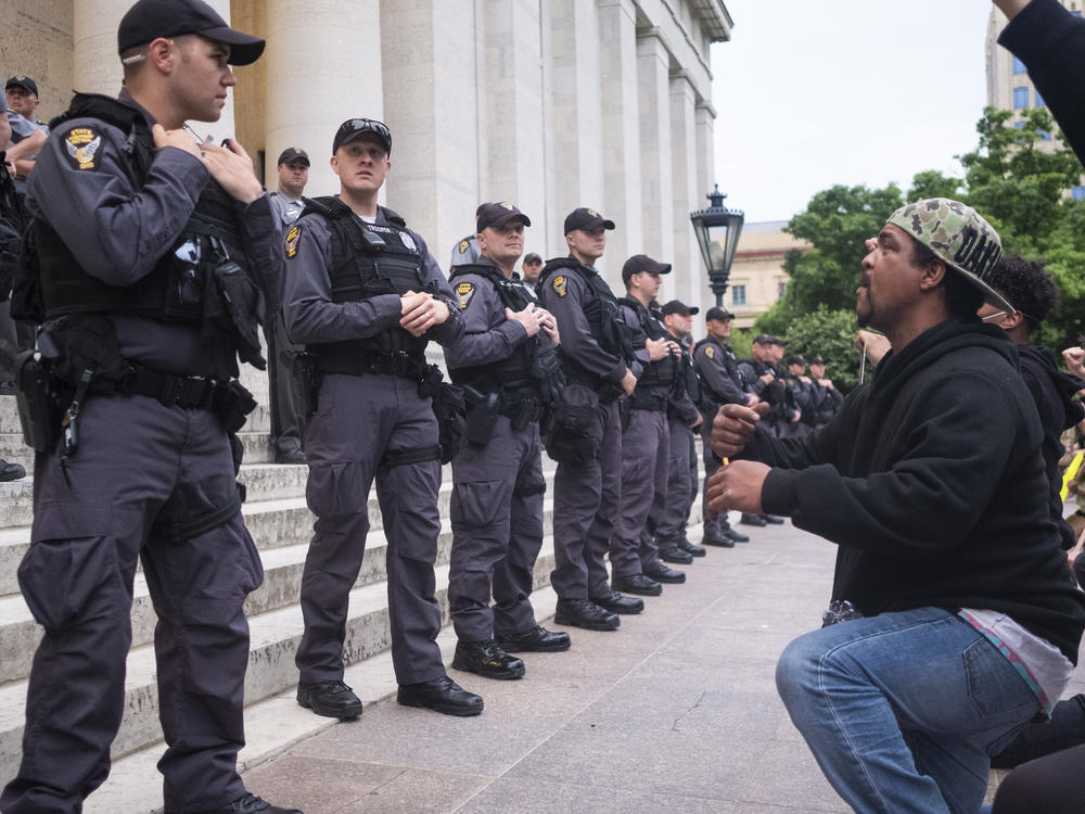 Protesters chant for Ohio state troopers and Columbus police to take a knee with them in solidarity on the Ohio Statehouse steps on June 1, 2020, in Columbus. A federal judge has ordered Columbus police to stop using force against nonviolent protesters.
