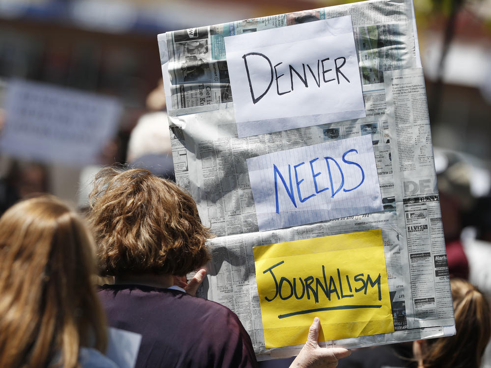 A sign from a rally against the ownership of the <em>Denver Post</em>, Alden Global Capital, in May 2018. Former <em>Post </em>journalists created <em>The Colorado Sun</em> that year; now <em>The Sun</em> has acquired two dozen suburban Denver papers.