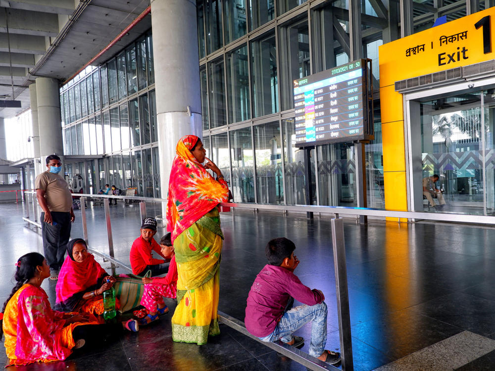 People wait at an exit gate at the Kolkata Airport Terminal. International air travel to and from India has been restricted as the country battles a catastrophic COVID-19 surge.