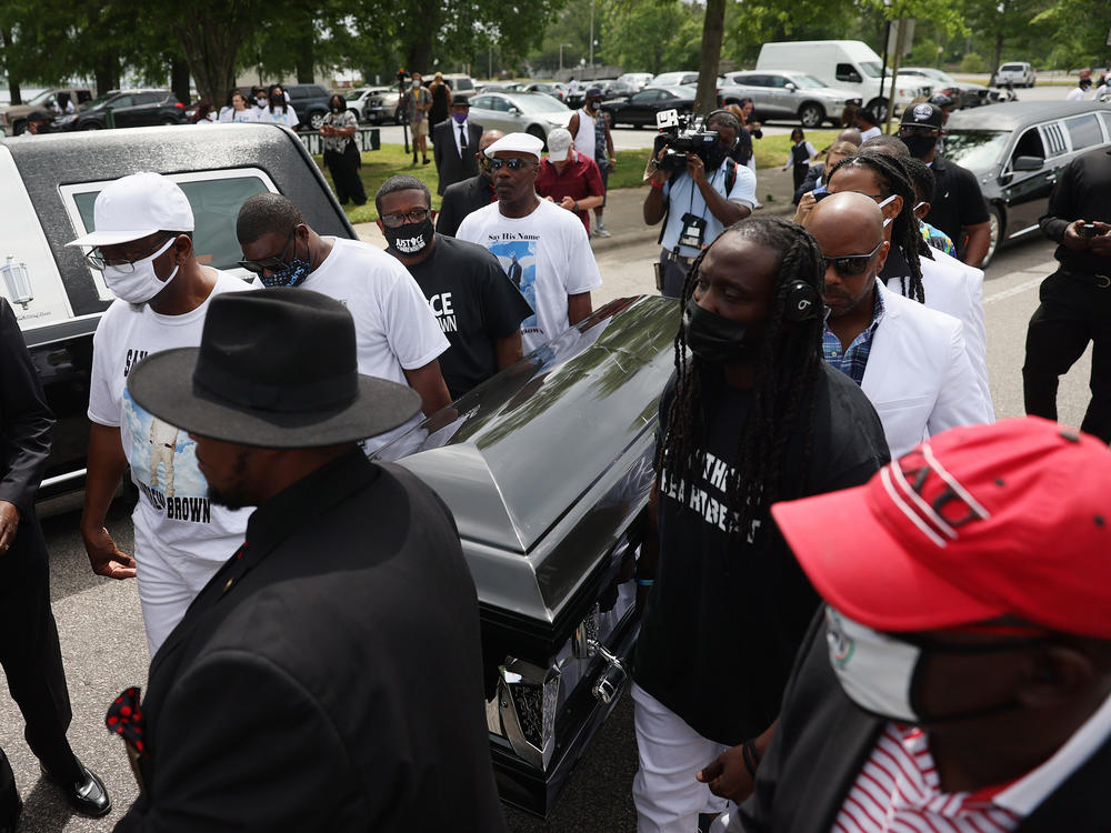 Pallbearers carry Brown's casket to a horse-drawn carriage before his funeral service Monday at the Fountain of Life Church in Elizabeth City, N.C.