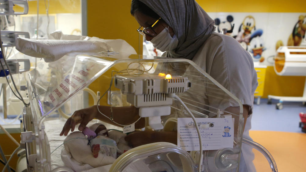 A nurse takes care of one of the nine babies protected in incubators at the maternity ward of a clinic in Casablanca, Morocco, on Wednesday. The mother was taken to Morocco for specialist care in late March.