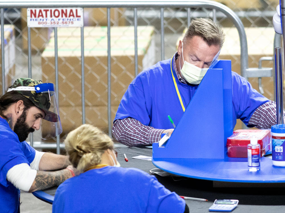 Contractors working for the firm Cyber Ninjas, which was hired by the Republican-led Arizona state Senate, count Maricopa County ballots from the 2020 general election at Veterans Memorial Coliseum on Saturday in Phoenix.