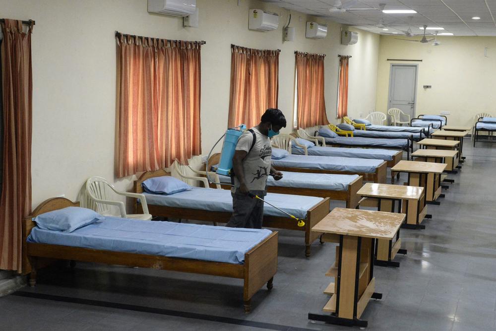 A worker sprays disinfectant inside a temporary quarantine center for COVID-19 patients this week in Hyderabad, India. Researchers estimate more than 400,000 people have died of COVID-19 in India than has been officially reported.