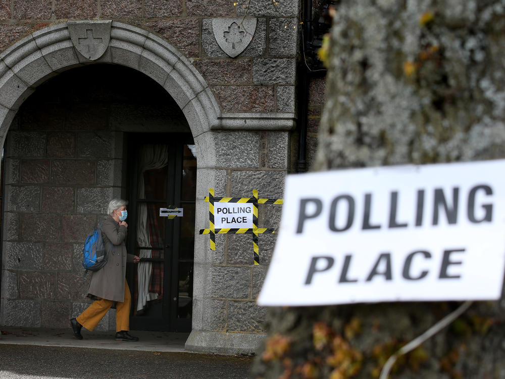 Voters arrive Thursday at the War Memorial building being used as a polling station in Aboyne in Aberdeenshire for Scotland's parliamentary election.