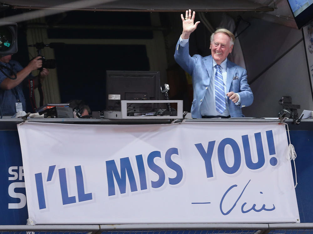 Los Angeles Dodgers broadcaster Vin Scully waves to the crowd after leading in the singing of Take Me Out to the Ball Game against the Colorado Rockies in 2016, his final season.
