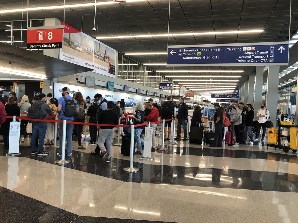 A line loops through security at Chicago's O'Hare International Airport as travelers return to the skies after mostly staying home during the coronavirus pandemic.