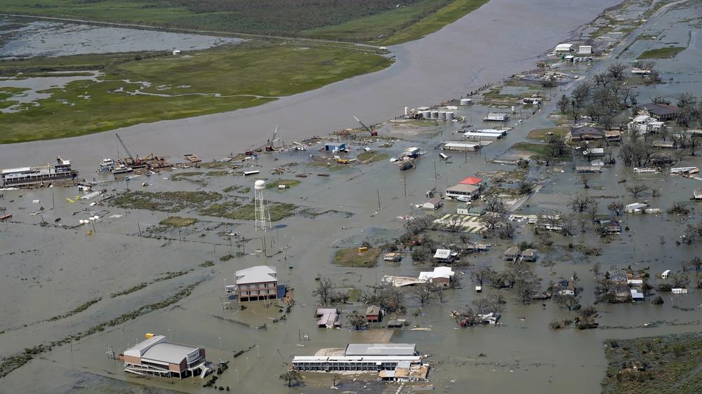 Buildings and homes are flooded in the aftermath of Hurricane Laura, on Aug. 27, 2020, in Cameron, La.  The warming climate is fueling more powerful storms, as well as intense rains and rising seas.