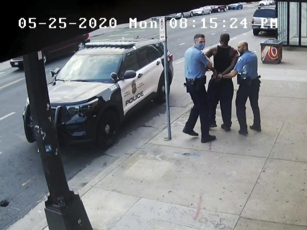 This image from video shows Minneapolis police officers Thomas Lane, left, and J. Alexander Kueng, right, escorting George Floyd, center, to a police vehicle outside Cup Foods in Minneapolis, on May 25, 2020. The image was shown as prosecutor Steve Schleicher gave closing arguments in the trial of Derek Chauvin for the death of Floyd.