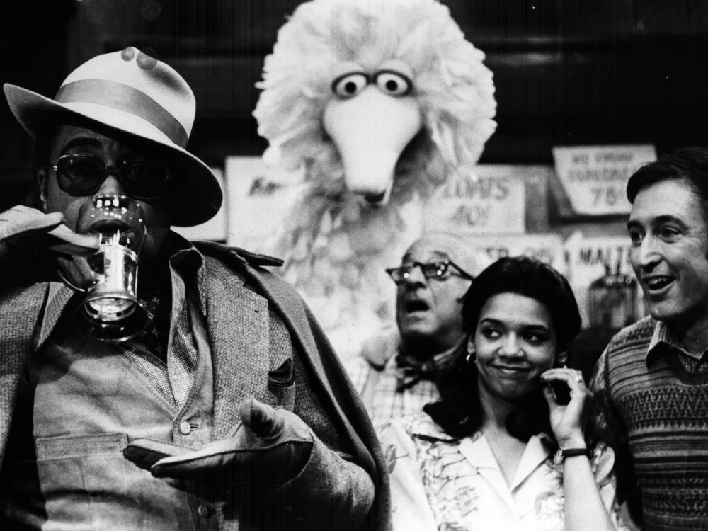 James Earl Jones guest stars on Sesame Street with regular cast members Big Bird, Mr. Hooper (played by actor Will Lee) and Maria (actor Sonia Manzano).