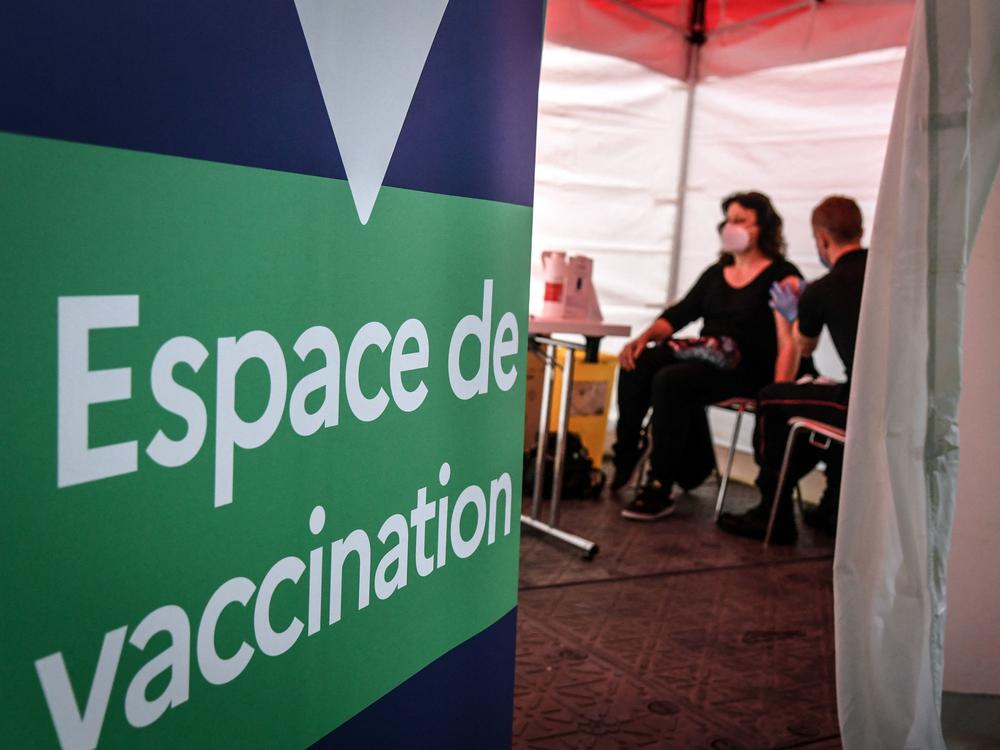 A firefighter administers the Pfizer-BioNTech COVID-19 vaccine at a vaccination center near Paris on Monday. The European Union has signed a deal to buy as many as 1.8 billion doses.