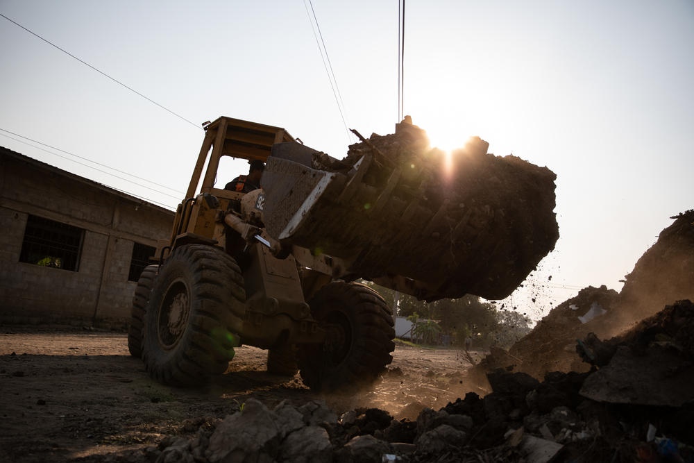 A bulldozer clears the way to the El Rosario neighborhood of La Lima, Honduras, after the neighborhood was cut off from the rest of the city for nearly six months. The 2020 hurricanes left tons of dirt and debris in the homes, alleys and roads of the neighborhood.