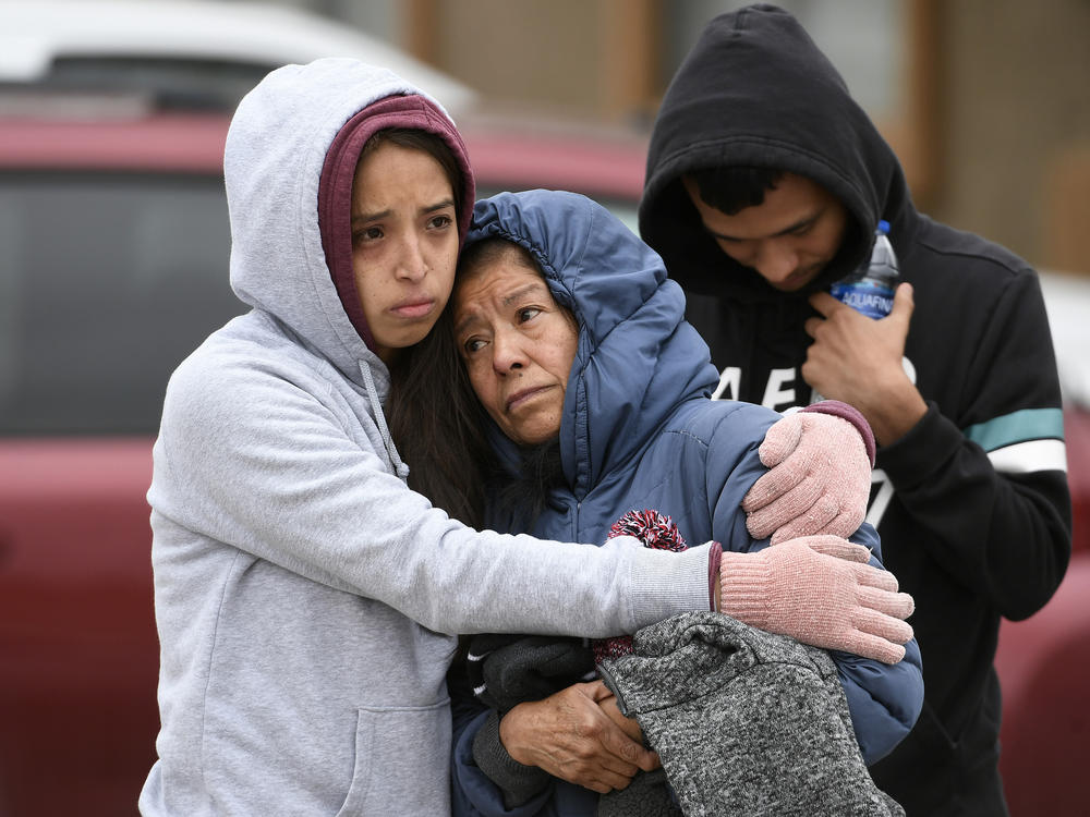 Family members of some of the six shooting victims hug one another outside the scene of the shooting at the Canterbury Mobile Home Park in Colorado Springs, Colo.