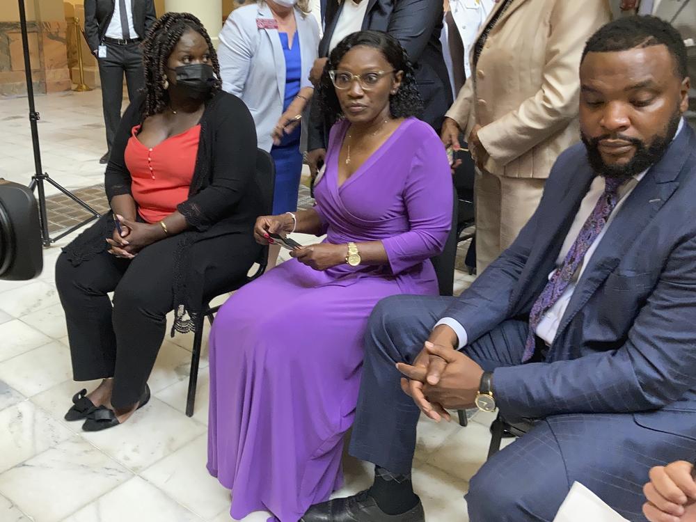 Ahmaud Arbery's relatives, including sister Jasmine Arbery (left) and his mother, Wanda Cooper-Jones (second from left), sit at the Georgia Capitol in Atlanta on Monday to witness Gov. Brian Kemp sign a law repealing the state's citizen's arrest statute.