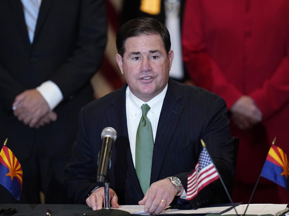 Arizona Republican Gov. Doug Ducey, seen here during an April 15 bill signing, on Tuesday signed legislation making it easier to remove infrequent voters from a list of those who automatically get a mail-in ballot each election.
