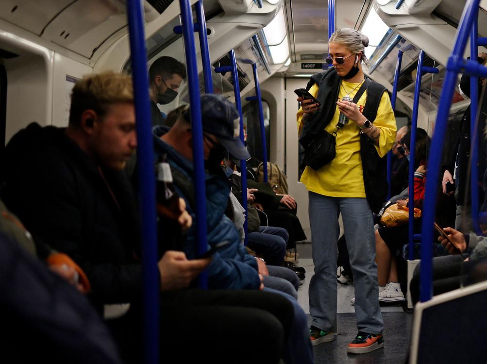 Passengers, some wearing protective face coverings and some not, travel during rush hour on the London Underground last month.