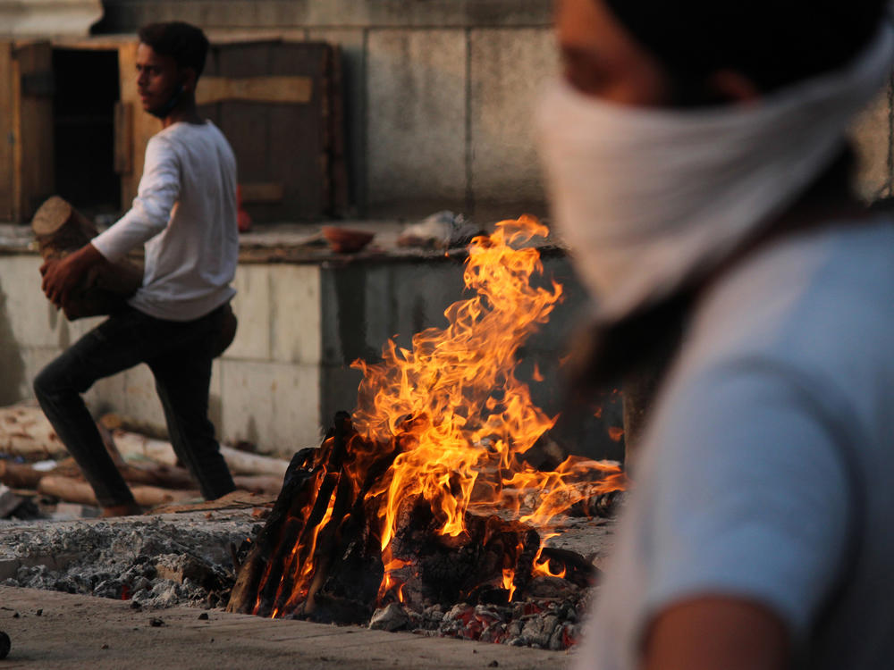 In New Delhi on Monday, family members cremate the body of a person who died after contracting COVID-19.