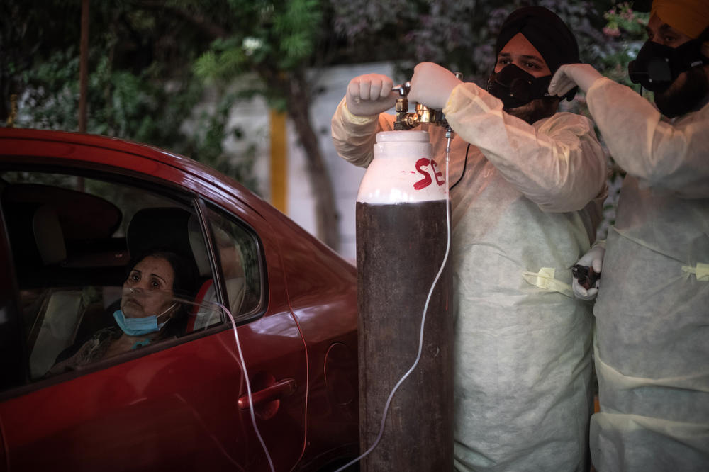 Patient Adila Ebadi, 58, who has been suffering from the coronavirus, is treated by volunteers at a makeshift clinic providing free oxygen outside the Gurdwara Damdama Sahib in New Delhi on May 3. India is struggling with shortages of oxygen for patients as well as shortages of medicine and hospital beds.