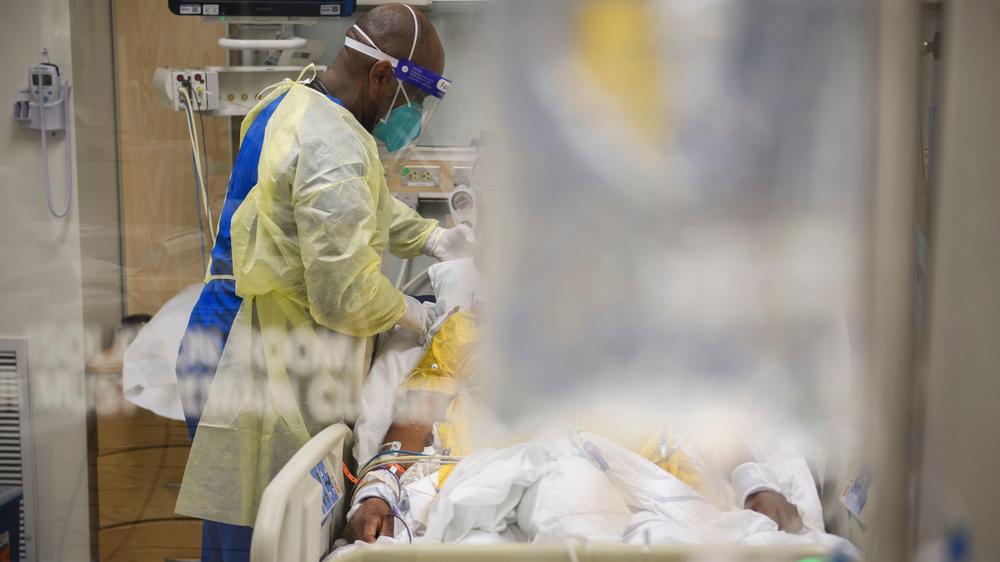 A hospital staff member attends to a patient in a COVID-19 intensive care unit on Jan. 6, 2021, at a hospital in Los Angeles.