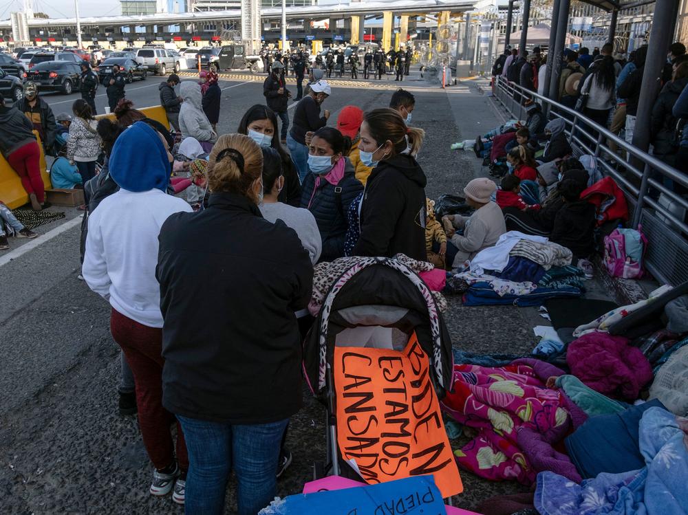 Migrants and asylum seekers are seen after spending the night in one of the car lanes off the San Ysidro Crossing Port on the Mexican side of the U.S.-Mexico border in Tijuana on April 24, 2021. A group of migrants asked U.S. migration authorities to allow them to start their migration process and decided to stay at the crossing port to pressure for a solution to their situation.