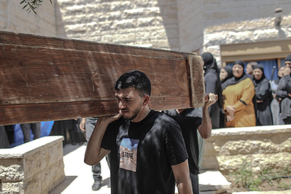 Mourners carry the coffin of Khalil Awad, 52, at the funeral for him and his 16-year-old daughter, Nadin Awad. The two Palestinian citizens of Israel were killed early Wednesday when a rocket fired from the Gaza Strip hit their home in Dahmash, a village near the city of Lod, Israel.