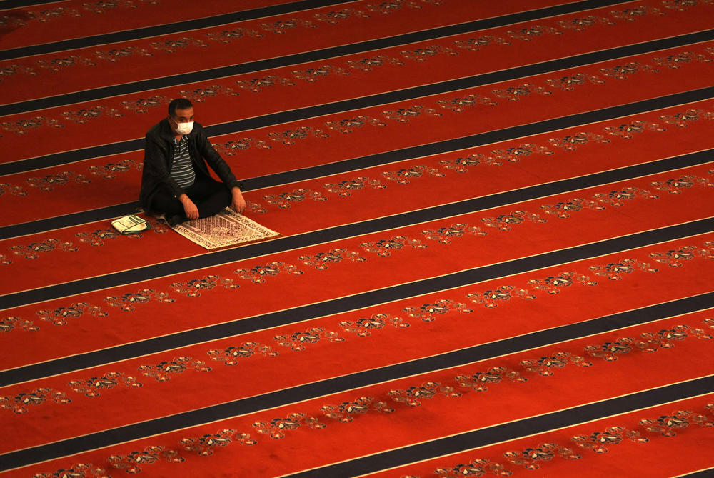 A man wearing a protective face mask and maintaining social distancing performs the Eid al-Fitr prayer at Kocatepe Mosque in Ankara, Turkey on Thursday.