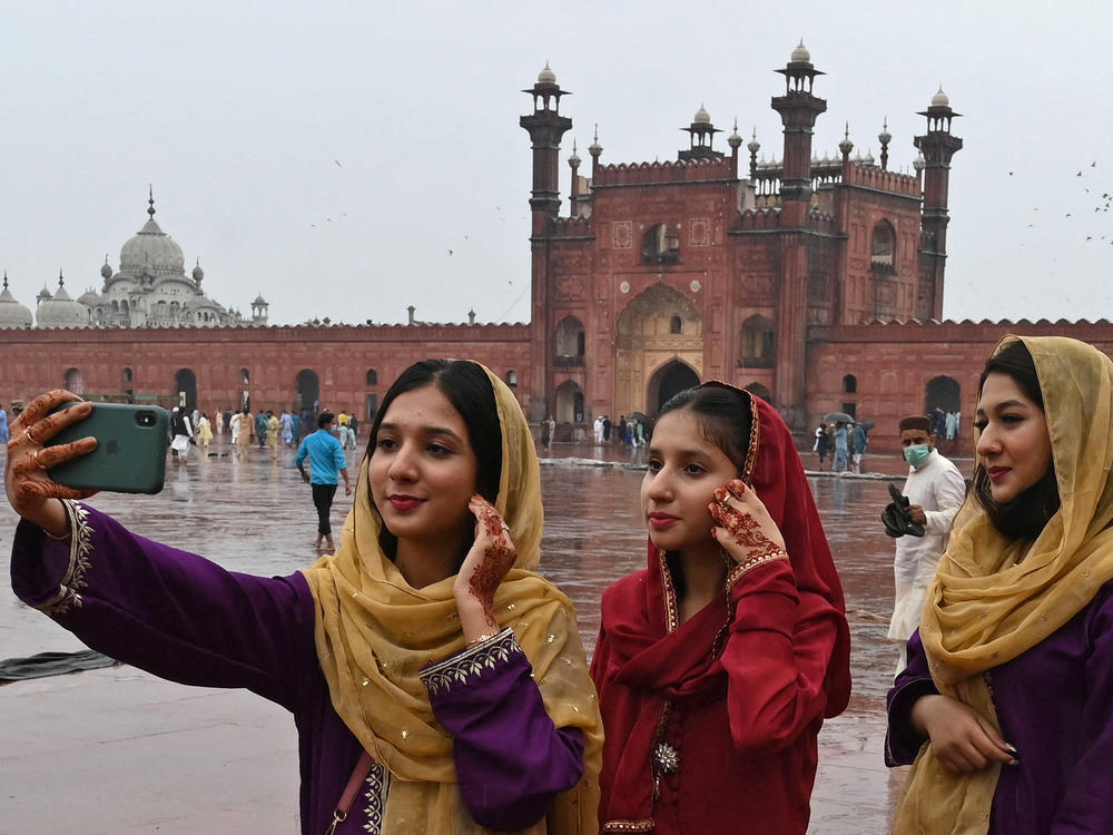 Muslim devotees takes a selfie using their mobile phones after offering special prayers at the historic Badshahi Mosque in Lahore, Pakistan.