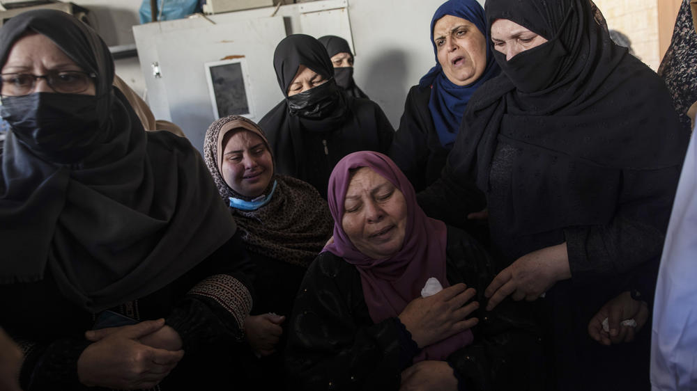 Relatives mourn over the bodies of four brothers who were found under the rubble of a destroyed house following Israeli airstrikes in Beit Lahiya in the northern Gaza Strip on Friday.