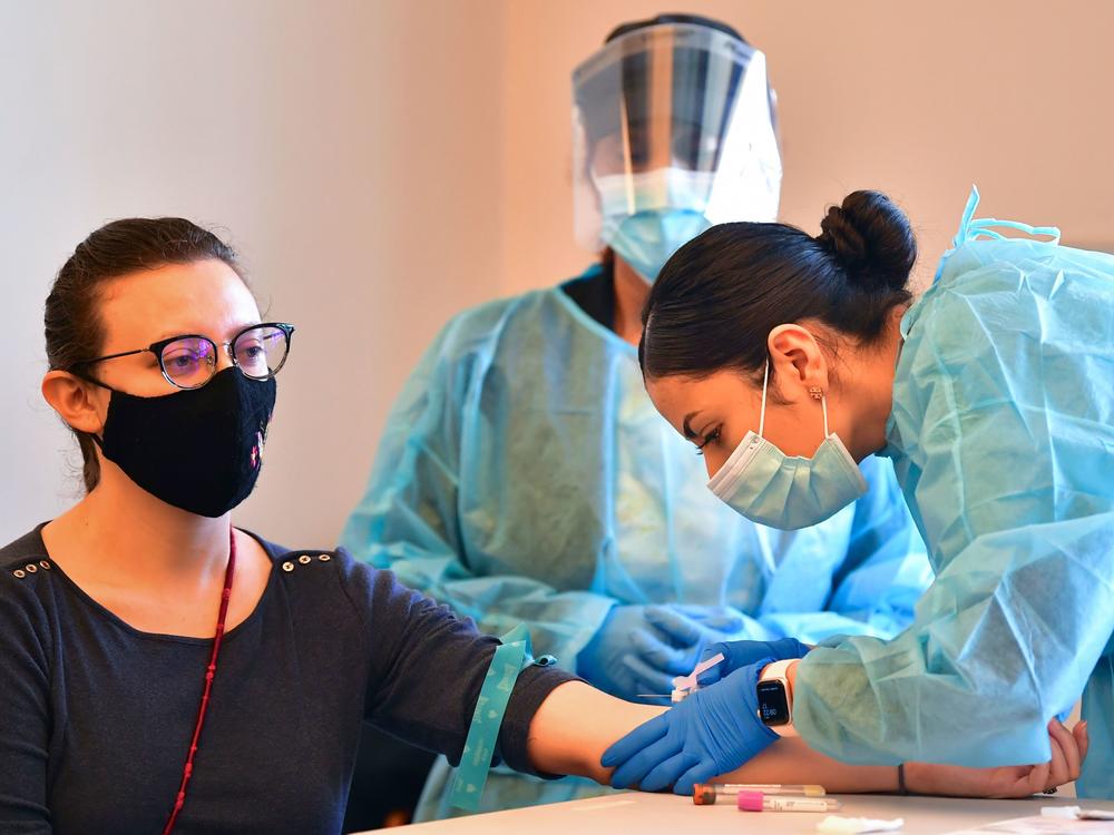 A phlebotomist draws blood at a free COVID-19 antibody testing event on Feb.17 in Pico Rivera, Calif.