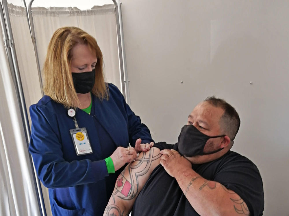 John Harrower, a truck driver from the Canadian province of Manitoba, receives a COVID-19 vaccine shot in North Dakota in late April.