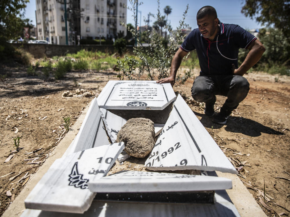 Jamal Abu Kasher looks at a vandalized grave Friday in a Muslim cemetery in the mixed Jewish-Arab city of Lod, Israel.