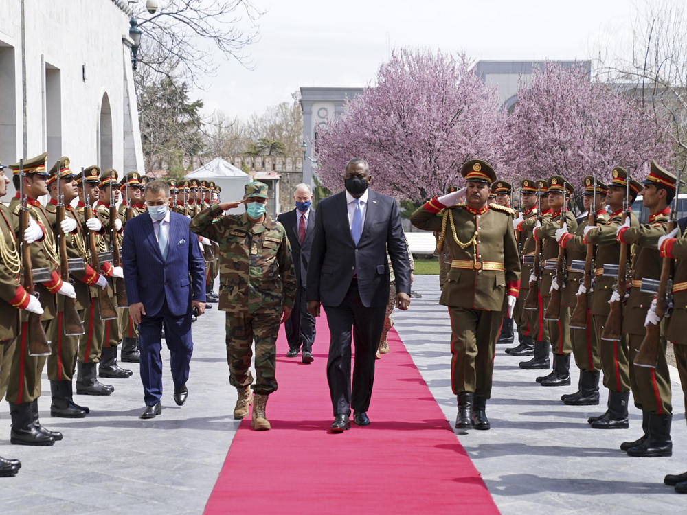 U.S. Defense Secretary Lloyd Austin (center) reviews an honor guard at Afghanistan's presidential palace in Kabul on March 21. President Biden says all U.S. troops will leave Afghanistan by September, though the Americans will still assist from 