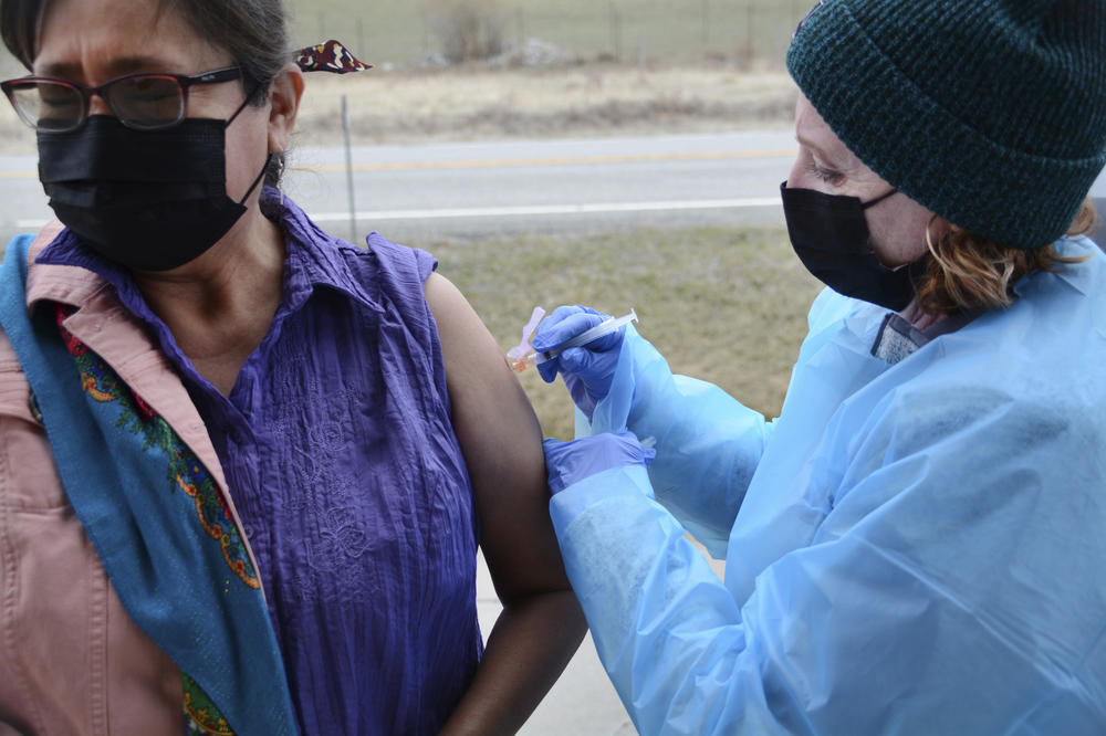 Sherry Cross Child, a Canadian resident of Stand Off, Alberta, receives a COVID-19 vaccine at the Piegan-Carway border crossing near Babb, Mont., on April 29. The Blackfeet tribe in northern Montana gave out surplus vaccines in April to its First Nations relatives and other residents from across the border.