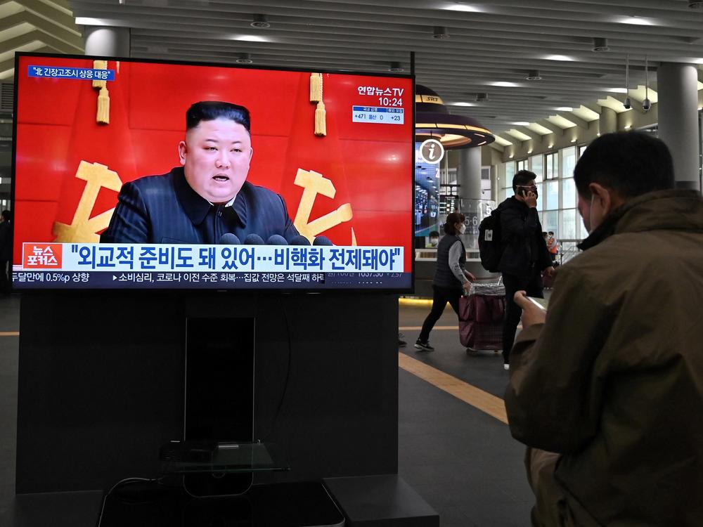 People watch a TV at Suseo train station in Seoul on March 26 as it shows file footage of North Korea's leader Kim Jong Un as a news program reports about the north's latest tactical guided projectile test.