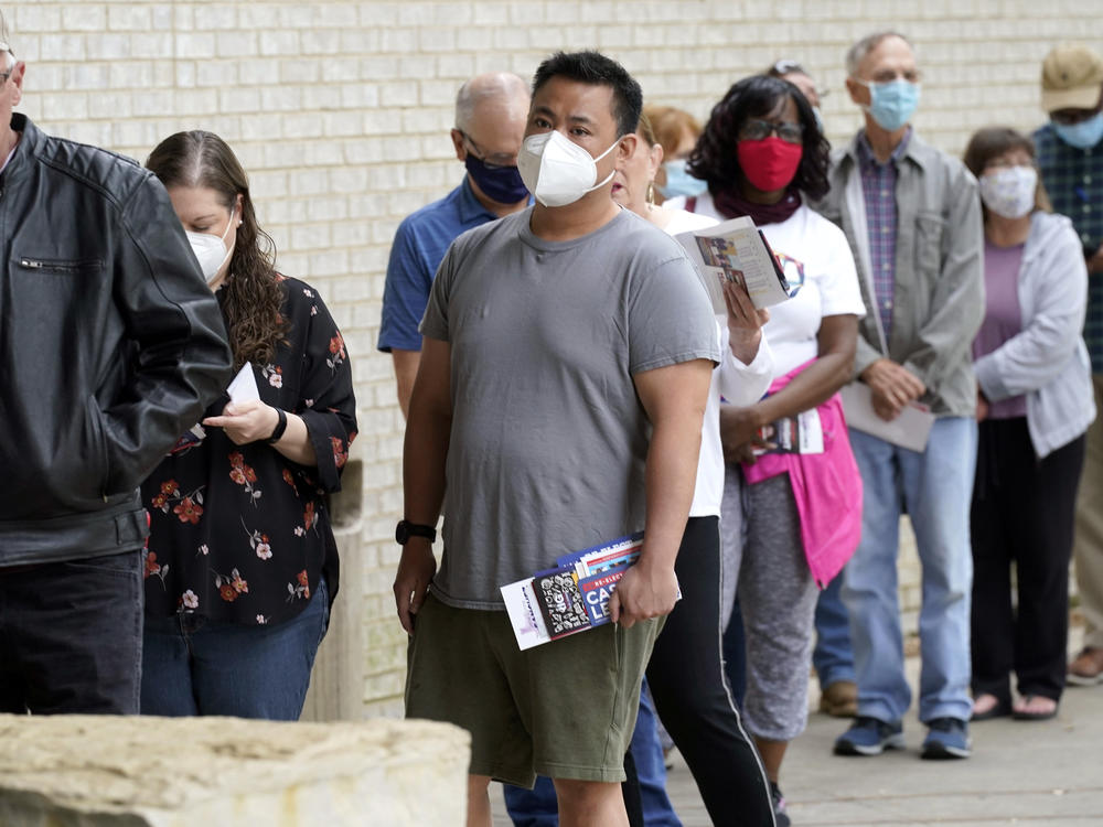 Voters are seen wearing masks in April as they prepared to cast ballots in Mansfield, Texas. The governor has now banned most state facilities from requiring masks.