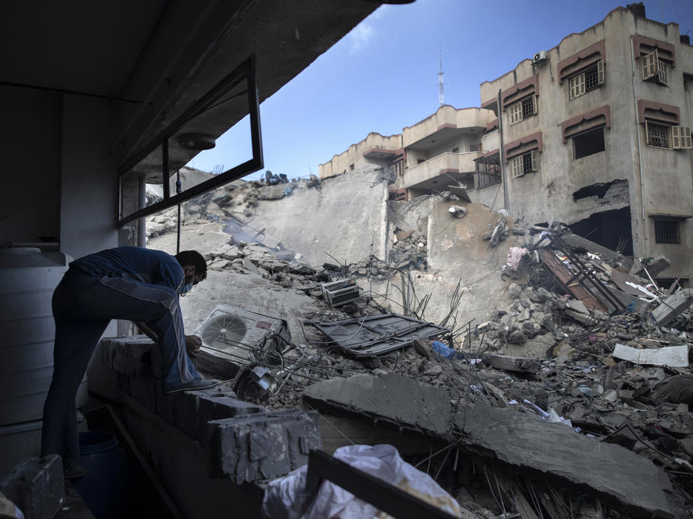 A Palestinian man inspects the damage of a six-story building destroyed by an early morning Israeli airstrike, in Gaza City on May 18, 2021.