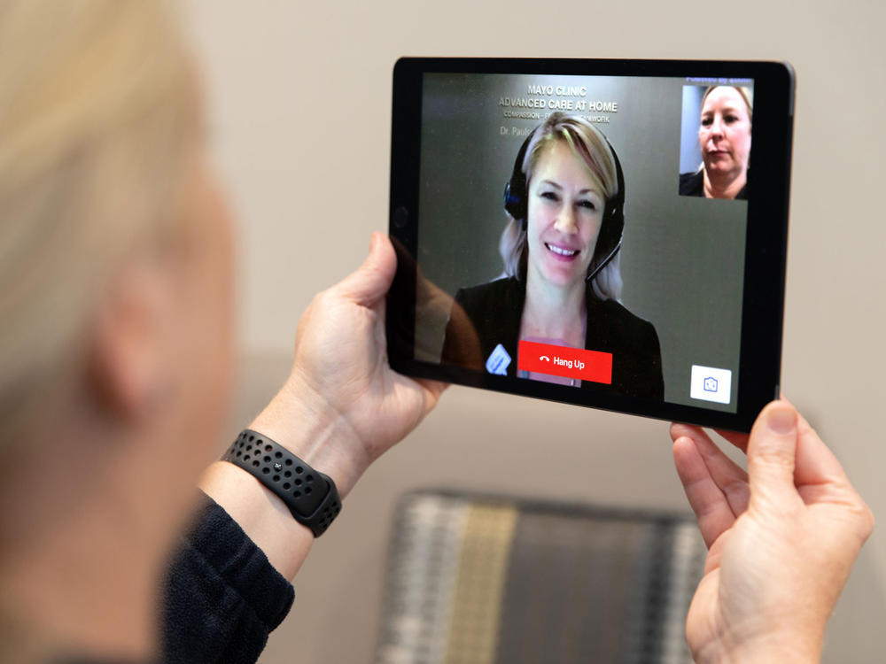 Dr. Margaret Paulson interacts with a patient via a tablet as part of Mayo Clinic's home-based hospital care program. Paulson says once patients understand that hospital-at-home care does not mean less care, they embrace it.